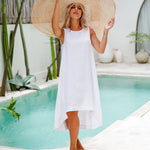 Woman in white sleeveless linen dress with oversized straw hat by pool in tropical setting — Magic Linen | Endless UAE