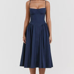 Woman wearing navy blue corset sundress with sweetheart neckline in garden setting — House of CB | Endless UAE