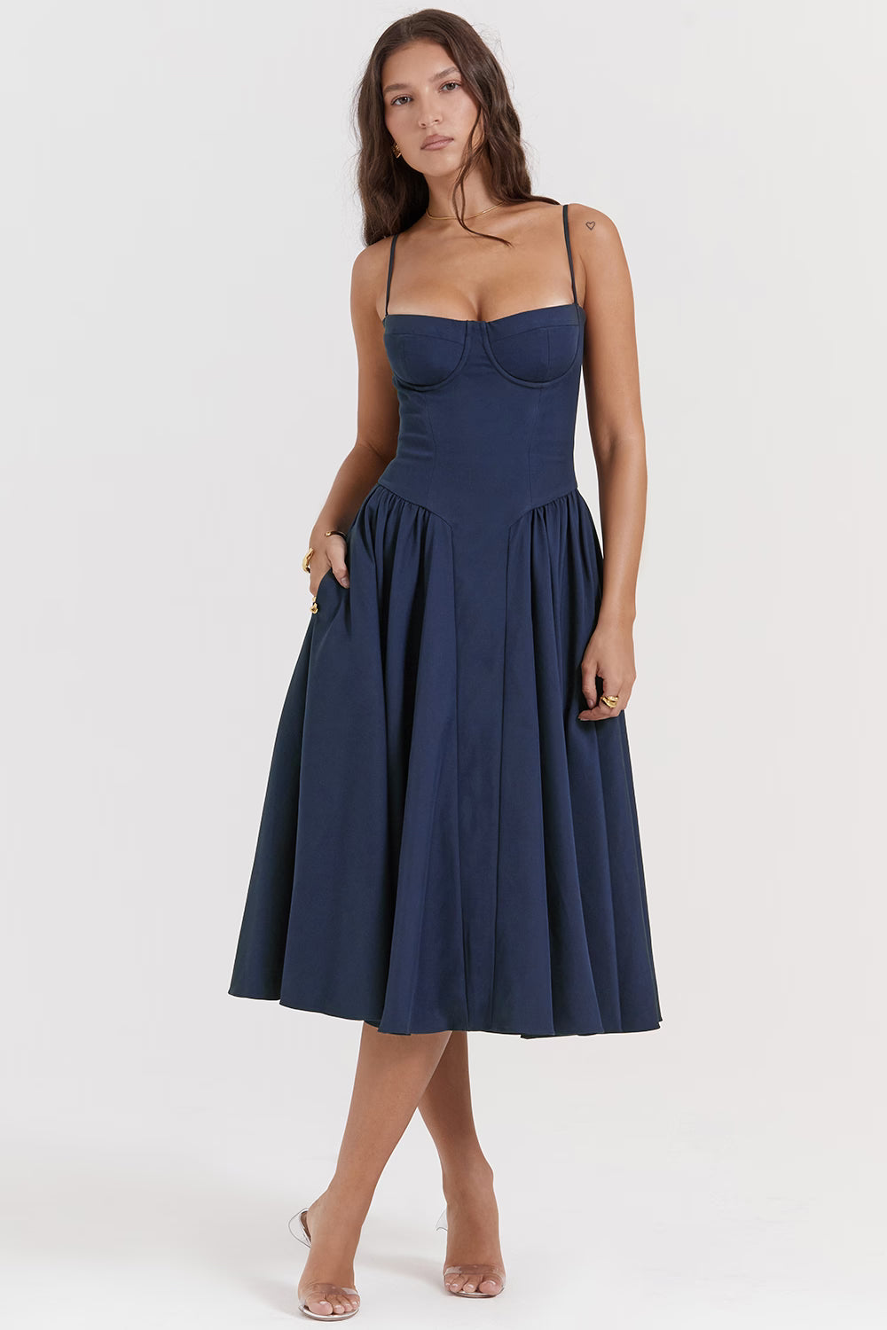 Woman wearing navy blue corset sundress with sweetheart neckline in garden setting — House of CB | Endless UAE