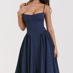Woman wearing navy blue corset sundress with sweetheart neckline in garden setting — House of CB | Endless UAE