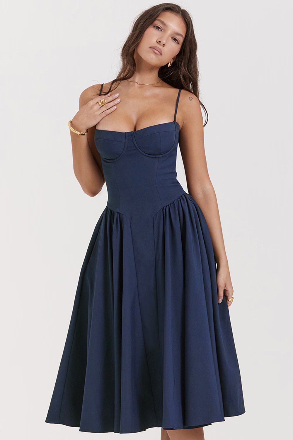 Woman wearing navy blue corset sundress with sweetheart neckline in garden setting — House of CB | Endless UAE