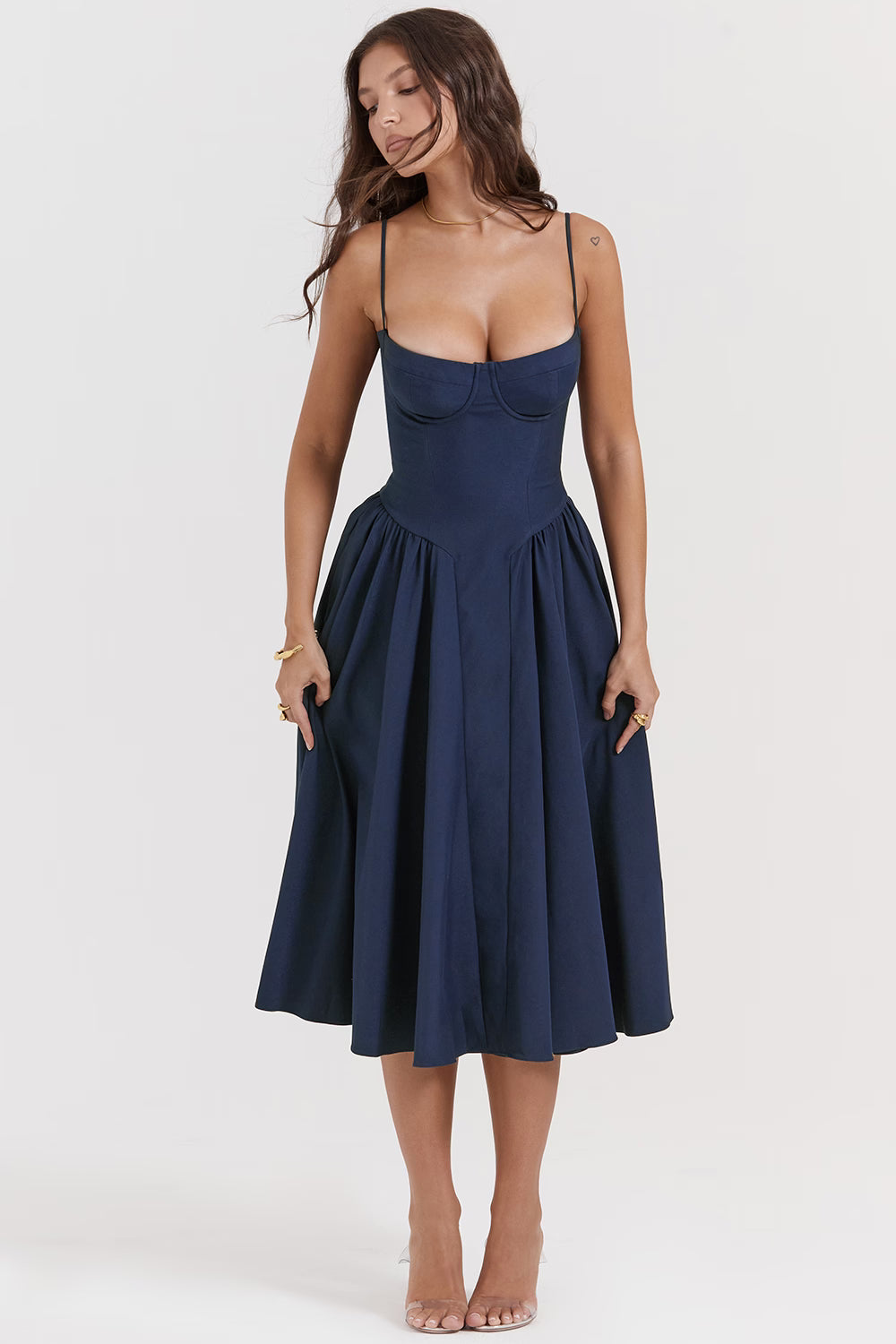 Woman wearing navy blue corset sundress with sweetheart neckline in garden setting — House of CB | Endless UAE