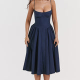 Woman wearing navy blue corset sundress with sweetheart neckline in garden setting — House of CB | Endless UAE