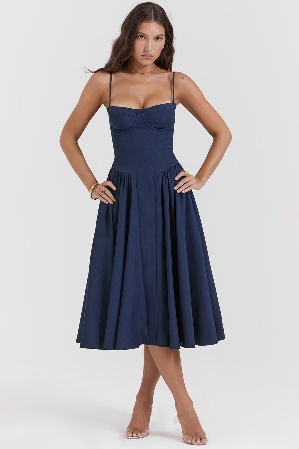 Woman wearing navy blue corset sundress with sweetheart neckline in garden setting — House of CB | Endless UAE