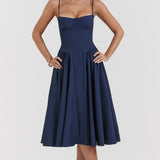 Woman wearing navy blue corset sundress with sweetheart neckline in garden setting — House of CB | Endless UAE