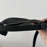 Black leather mini shoulder bag with textured finish held open to show interior — By Far | Endless UAE