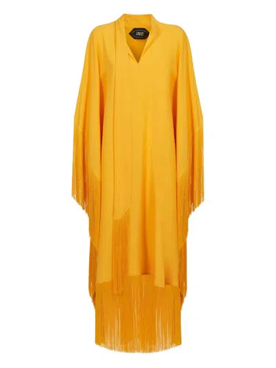 Woman wearing a yellow and orange fringed kaftan with black bag and sandals — Taller Marmo | Endless UAE