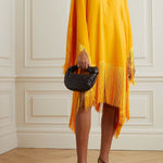 Woman wearing a yellow and orange fringed kaftan with black bag and sandals — Taller Marmo | Endless UAE