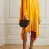 Woman wearing a yellow and orange fringed kaftan with black bag and sandals — Taller Marmo | Endless UAE