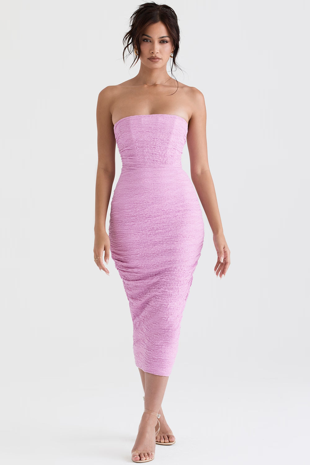 Model wearing pink strapless bodycon midi dress with ruched texture and corset styling for evening occasions — House of CB | Endless UAE