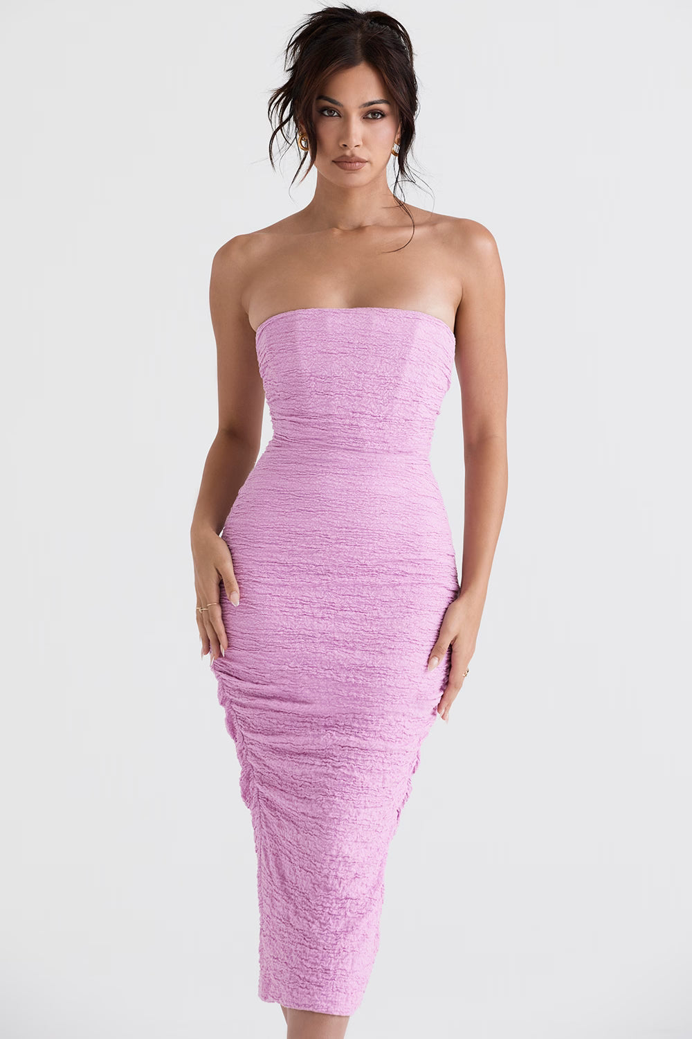 Model wearing Tana pink strapless corset midi dress with textured ruched fabric and figure-hugging silhouette — House of CB | Endless UAE
