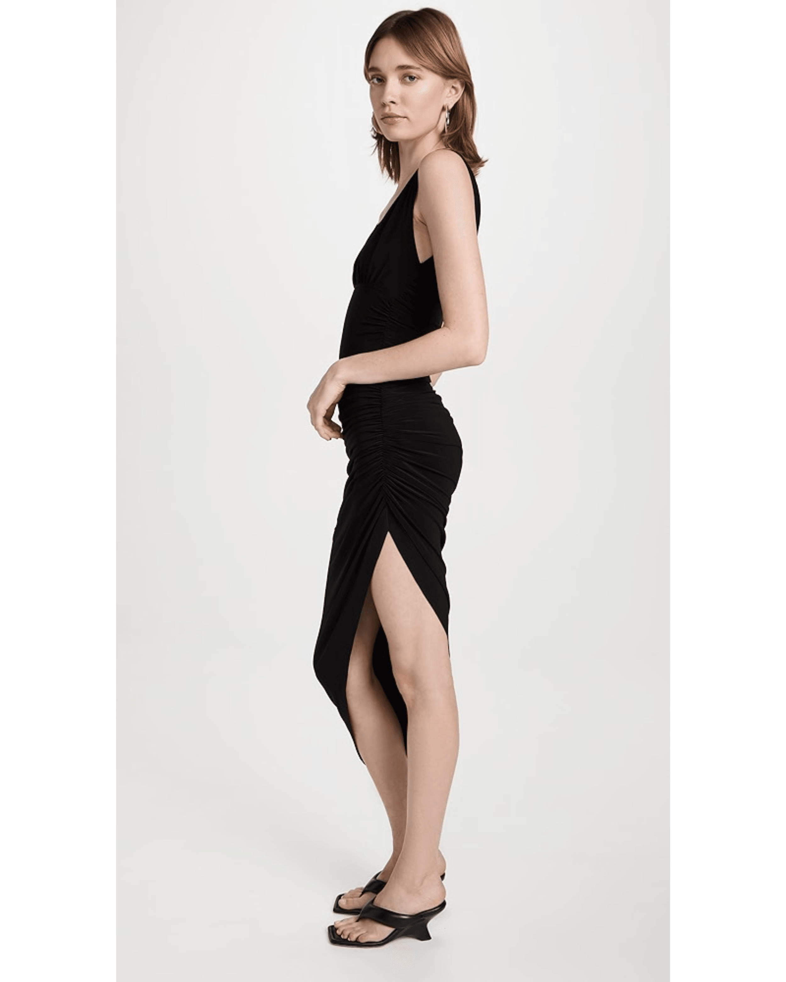 Woman wearing black sleeveless side draped gown with asymmetric hemline and ruched detailing — Norma Kamali | Endless UAE