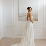 Elegant strapless wedding dress with flowing train and fitted bodice in minimal white design — You&I Bridal | Endless UAE
