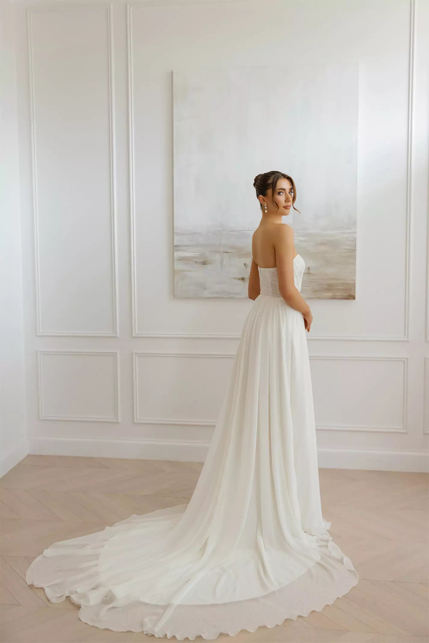 Elegant strapless wedding dress with flowing train and fitted bodice in minimal white design — You&I Bridal | Endless UAE