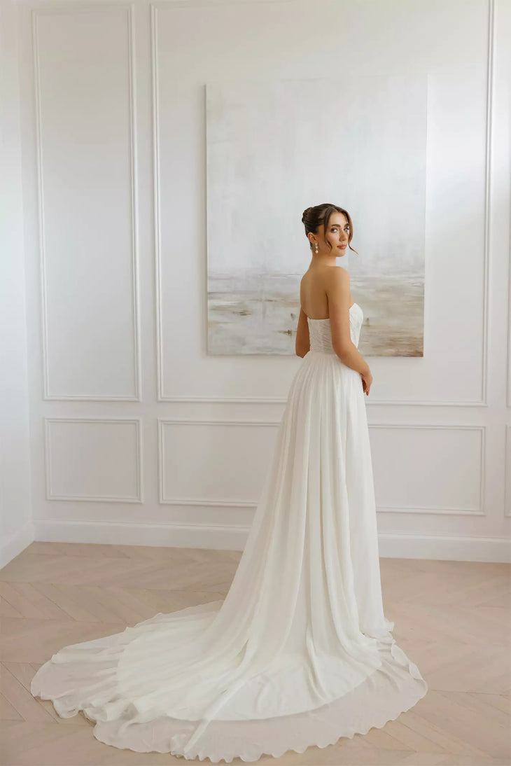 Elegant strapless wedding dress with flowing train and fitted bodice in minimal white design — You&I Bridal | Endless UAE