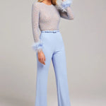 Woman wearing lavender beaded crop top with feathered cuffs and light blue wide-leg trousers — Nadine Merabi | Endless UAE