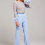 Woman wearing lavender beaded crop top with feathered cuffs and light blue wide-leg trousers — Nadine Merabi | Endless UAE