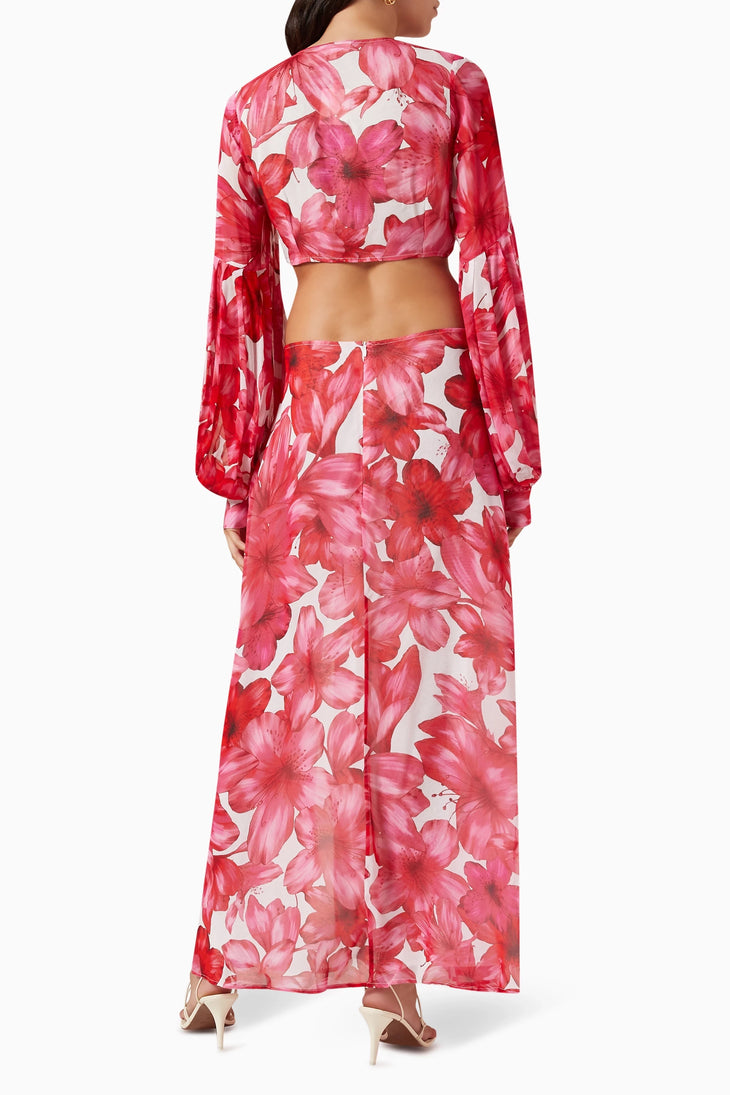 Woman wearing red floral cut-out maxi dress with long sleeves and gold sandals — Alexandra Miro | Endless UAE