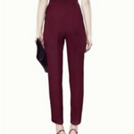 Rear view of woman wearing plum halter tailored jumpsuit with high waist and tapered legs, holding black clutch — Gucci | Endless UAE