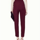Rear view of woman wearing plum halter tailored jumpsuit with high waist and tapered legs, holding black clutch — Gucci | Endless UAE