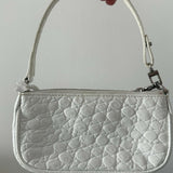 White quilted mini shoulder bag with silver hardware held up against neutral background — By Far | Endless UAE