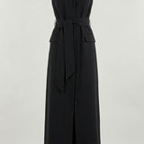 Woman wearing black sleeveless belted maxi dress by the seaside — LA Collection | Endless UAE