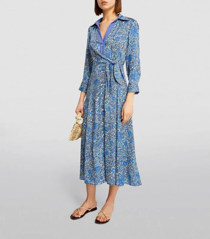 Woman wearing blue floral print midi dress with long sleeves, collar and tie waist detail paired with beige sandals — Sandro | Endless UAE