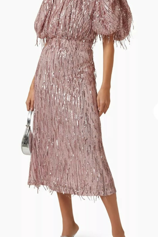 Woman wearing a dusty pink sequin fringe midi dress with puffed sleeves — Endless | Endless UAE