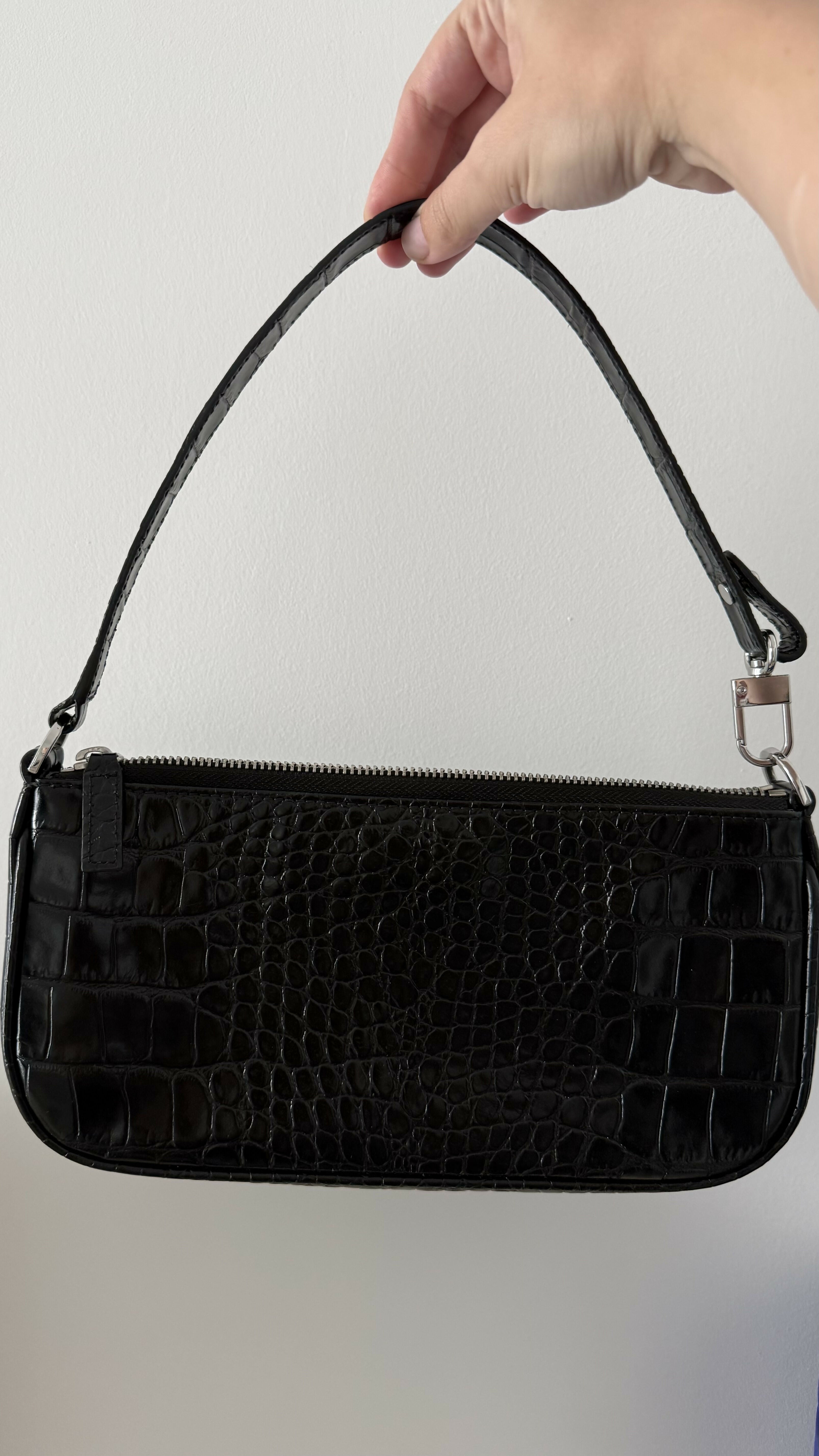 Black crocodile embossed leather shoulder bag held in hand against white background — By Far | Endless UAE