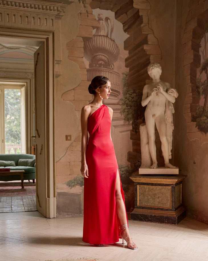 Woman in elegant red one-shoulder gown with high slit in classical interior setting — Miphai | Endless UAE