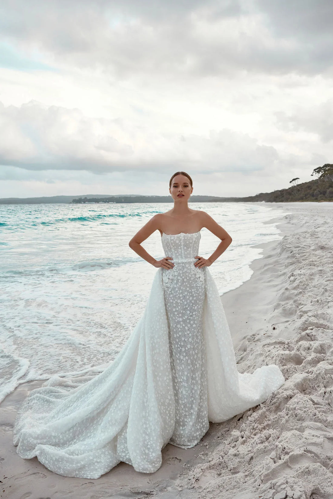 Alaia bridal gown featuring beaded bodice and flowing tulle train on beach — Wona Concept | Endless UAE