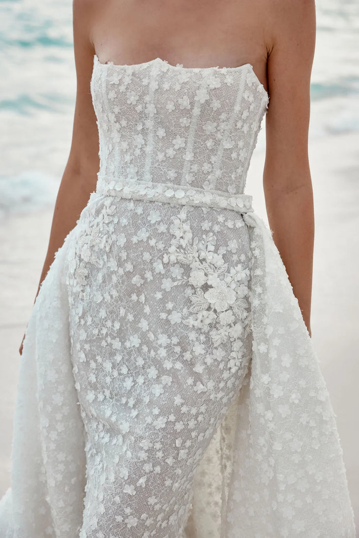 Alaia bridal gown featuring beaded bodice and flowing tulle train on beach — Wona Concept | Endless UAE