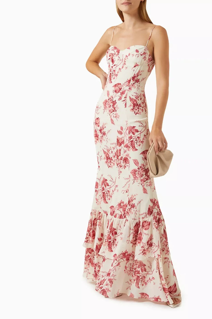Woman wearing a cream and pink floral maxi dress with spaghetti straps and tiered ruffled hem — Reformation | Endless UAE