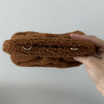 Gea Clutch in caramel brown textured fabric held in hand — TheMoire | Endless UAE