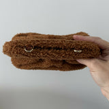 Gea Clutch in caramel brown textured fabric held in hand — TheMoire | Endless UAE