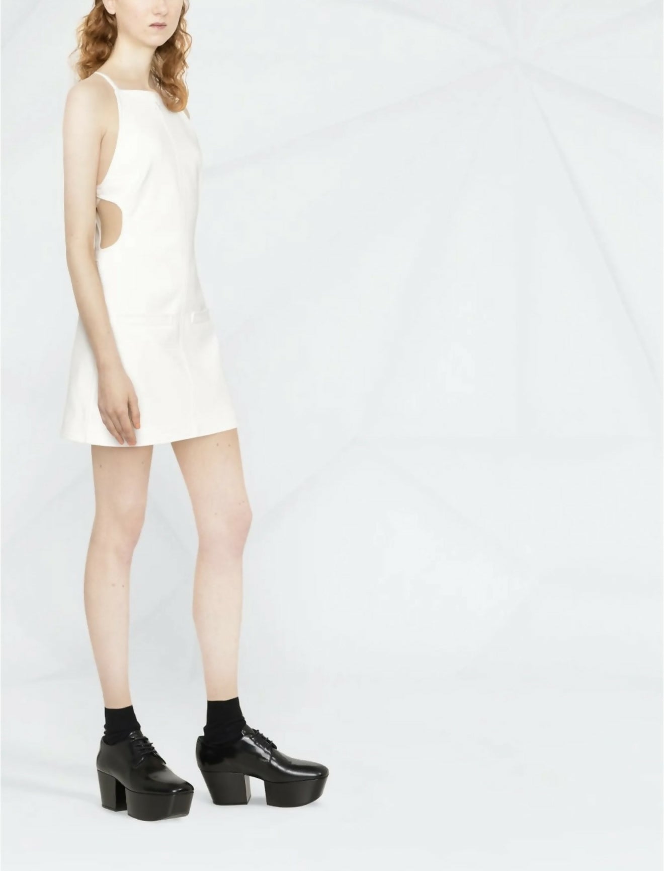 White sleeveless mini dress with side cutouts paired with black platform shoes — Courrèges | Endless UAE