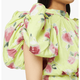 Woman wearing yellow floral puff-sleeve top with white midi skirt and blue sandals — Rotate Birger Christensen | Endless UAE