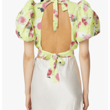 Woman wearing yellow floral puff-sleeve top with white midi skirt and blue sandals — Rotate Birger Christensen | Endless UAE