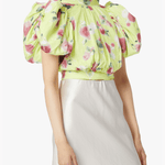 Woman wearing yellow floral puff-sleeve top with white midi skirt and blue sandals — Rotate Birger Christensen | Endless UAE