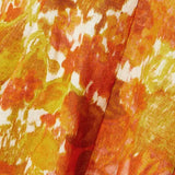 Close-up of vibrant orange and yellow floral-print linen fabric with painterly brushstroke pattern — Zimmermann | Endless UAE