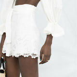 White embroidered shorts with scalloped hem and belt, worn with matching off-shoulder top — Zimmermann | Endless UAE
