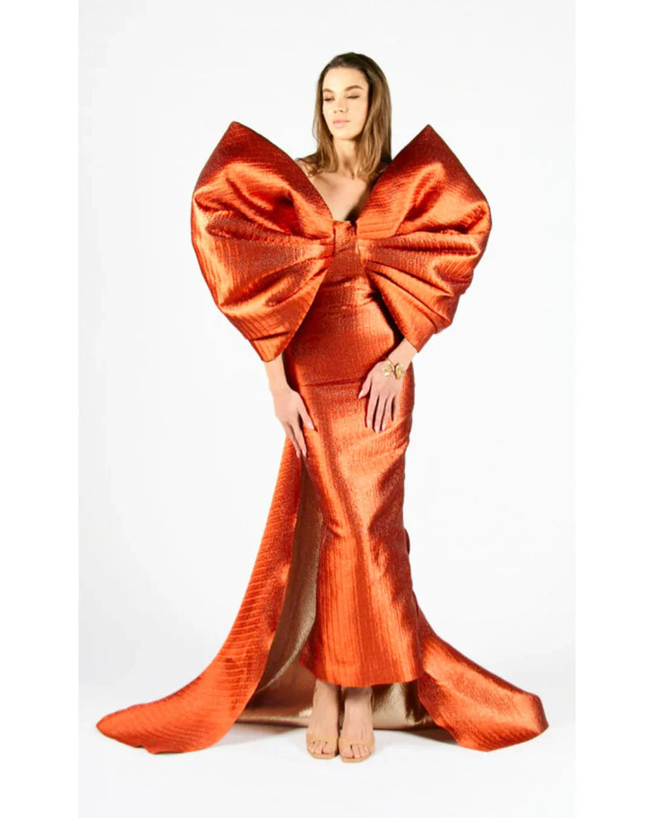 Woman wearing vibrant orange Grace 3D Shoulder Bow gown with dramatic back tail — Anaya Collection | Endless UAE