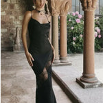 Woman wearing black satin maxi dress with lace side detail and halter neckline — Meshki | Endless UAE